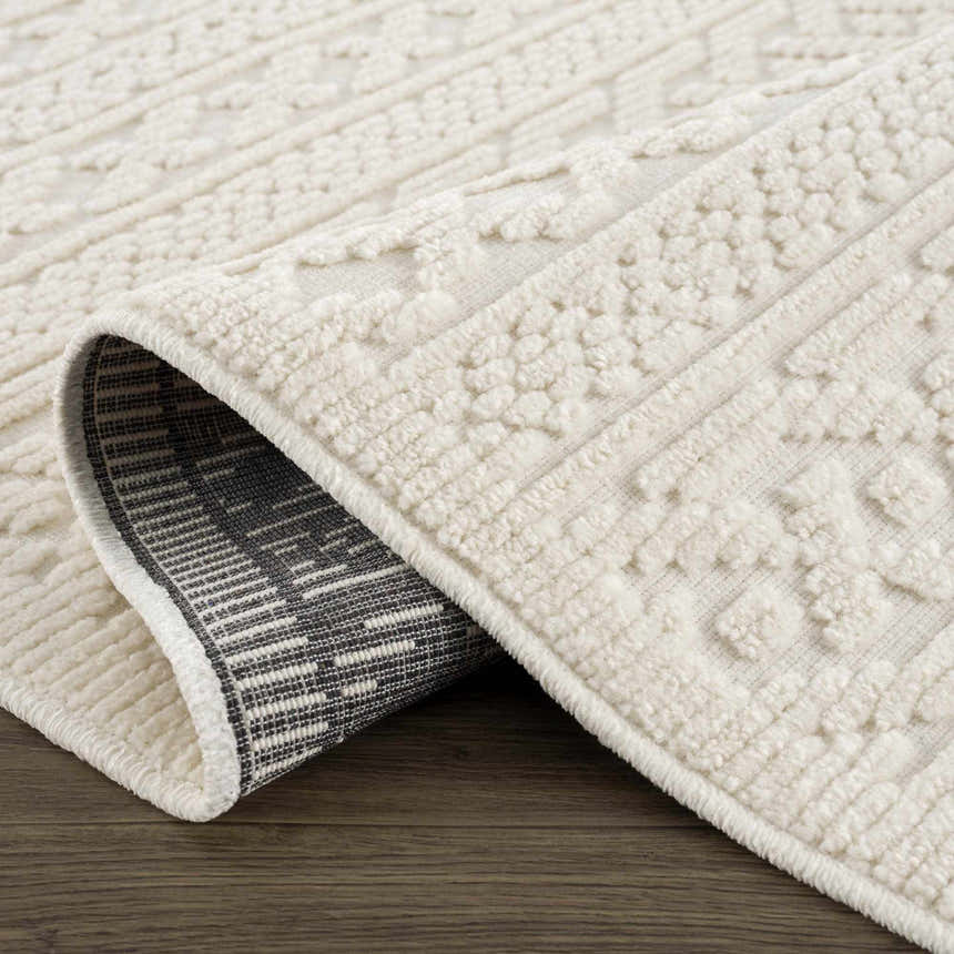 Close-up of the Fadey White 3D Washable Rug showing its geometric pattern and soft, textured pile on a wood floor. Fold