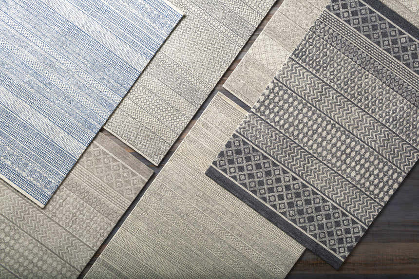 Close-up of assorted rugs, including the Lone Beige Tufted Maroc Wool Rug, showing geometric patterns and textures. Styleshot