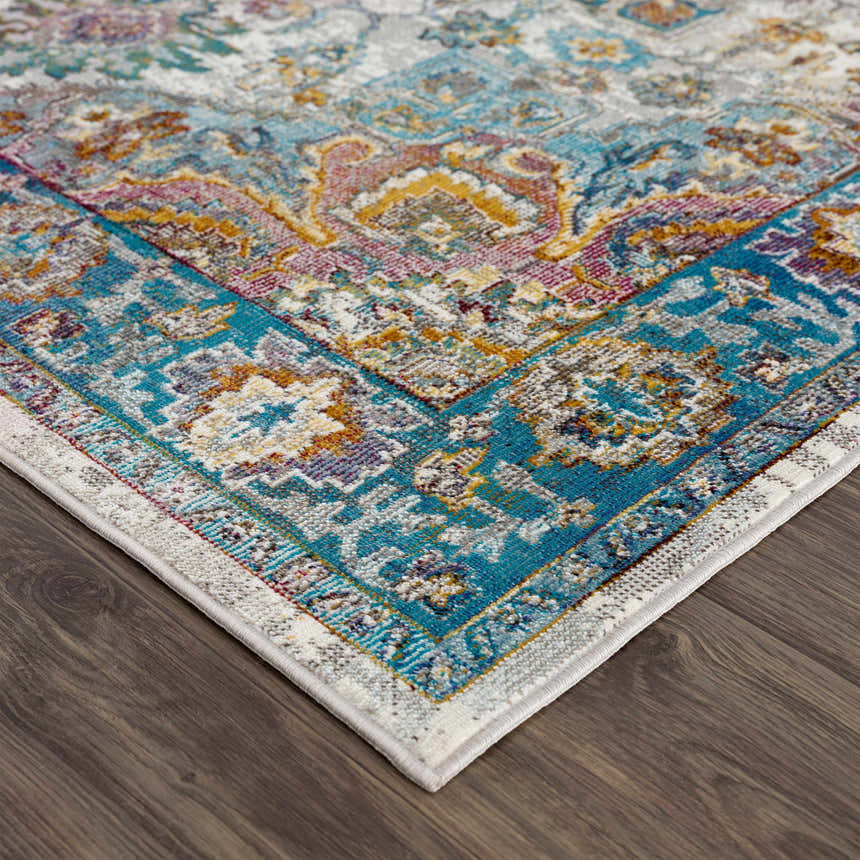 Close-up of Mardin Colorful Area Rug showing blue, pink, and mustard tones. Traditional design on a polypropylene rug. Corner