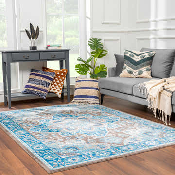Living room scene with a turquoise Mardin rug, gray sofa, console table, and wood floors. Roomscene-Rectangle