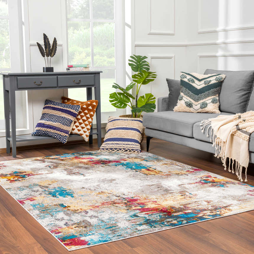 Living room scene with gray sofa and Mardin Abstract Area Rug in blue, pink, mustard, and gray. Roomscene-Rectangle
