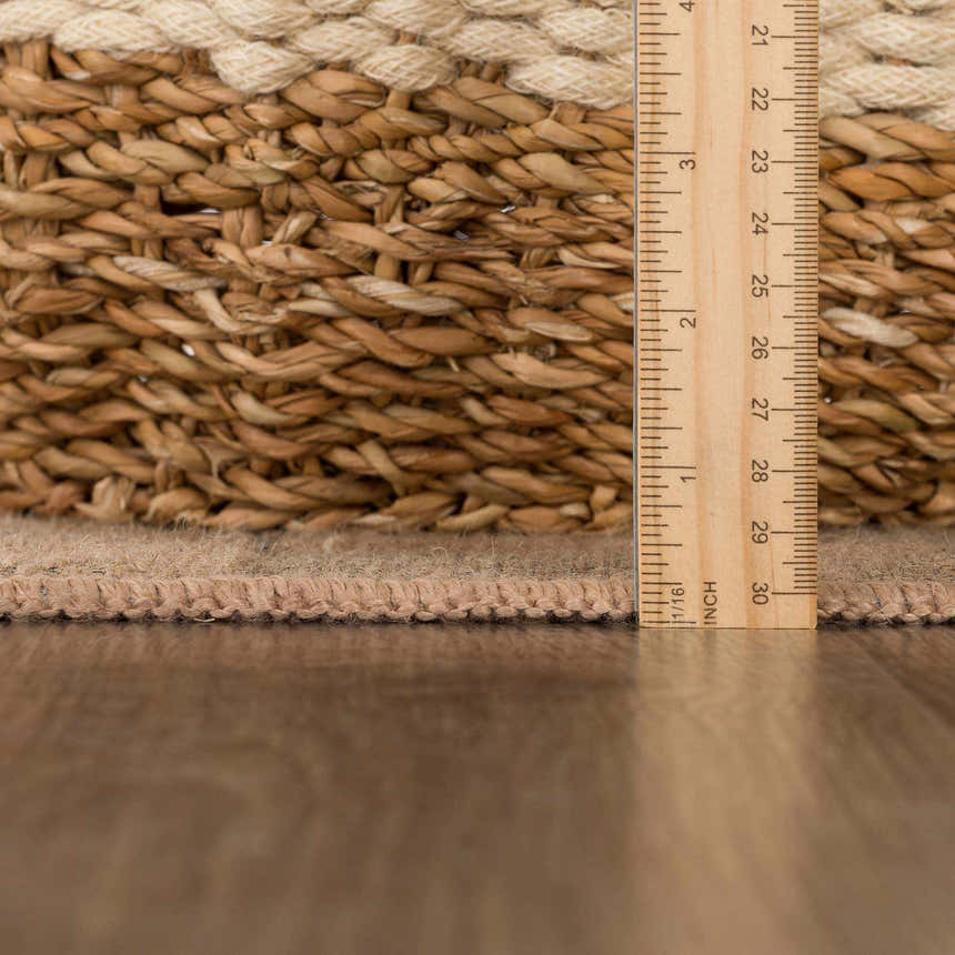 Close up of the Nairi Checkered Washable Jute Rug showing texture, jute braiding, and thickness with a ruler. Pile