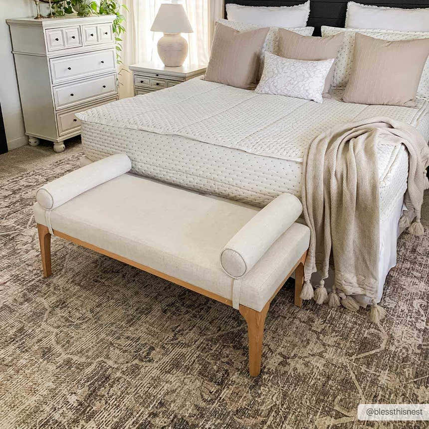 Bedroom scene with a Marlene Medallion Brown Area Rug, cream bench, white bedding, and neutral accents. Roomscene-Rectangle