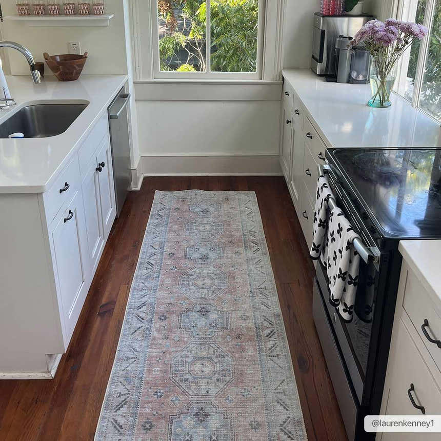 Bright kitchen with Morcott Peach Washable Area Rug runner on hardwood floor between white cabinets and oven. Roomscene-Runner