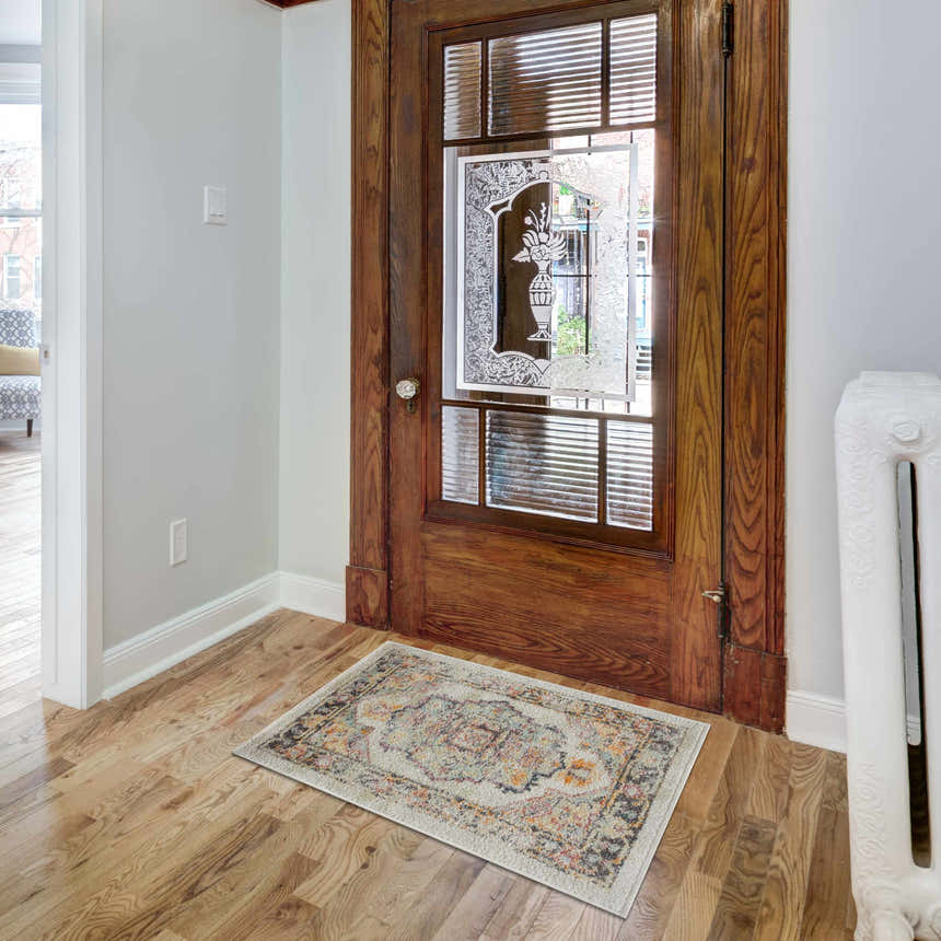 Entryway with a beige, blue, and red Hillcrest Area Rug in front of a vintage wooden door. Roomscene-Rectangle