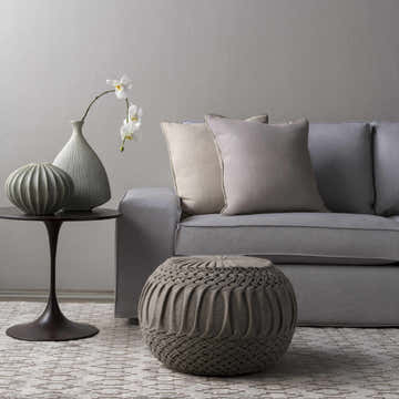 Living room scene with gray sofa, ottoman, and the Lamoni Viscose Area Carpet in medium gray with a contemporary striped pattern. Styleshot