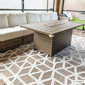 Outdoor patio scene with a Nuri Tan rug, white sofa, and brown fire pit table. Geometric pattern rug. Roomscene-Rectangle