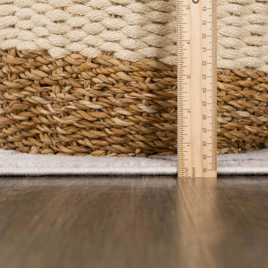 Close up of the Azzan Cream & Charcoal Area Rug showing the pile height with a ruler. Cream rug texture. Pile