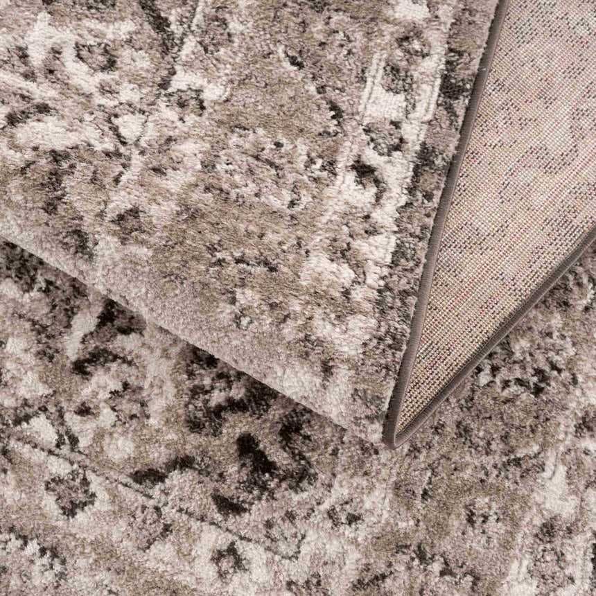 Close-up of the Albie Charcoal & Beige Area Rug showing its traditional pattern, soft texture, and woven backing. Fold