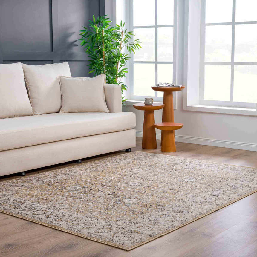 Living room scene with a beige sofa and the Anana Gold & Beige Area Rug adding warmth to the wood floor. Roomscene-Rectangle
