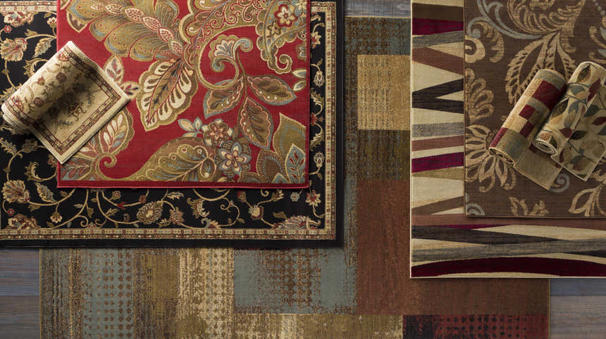 Overhead shot of various rug patterns and textures, including the red Ober Fall Leaves Rug with floral design. Styleshot