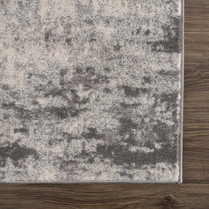 Close-up of the Kalanganan Abstract Gray Rug showing its charcoal, gray, and off-white abstract pattern and machine-woven texture. Swatch