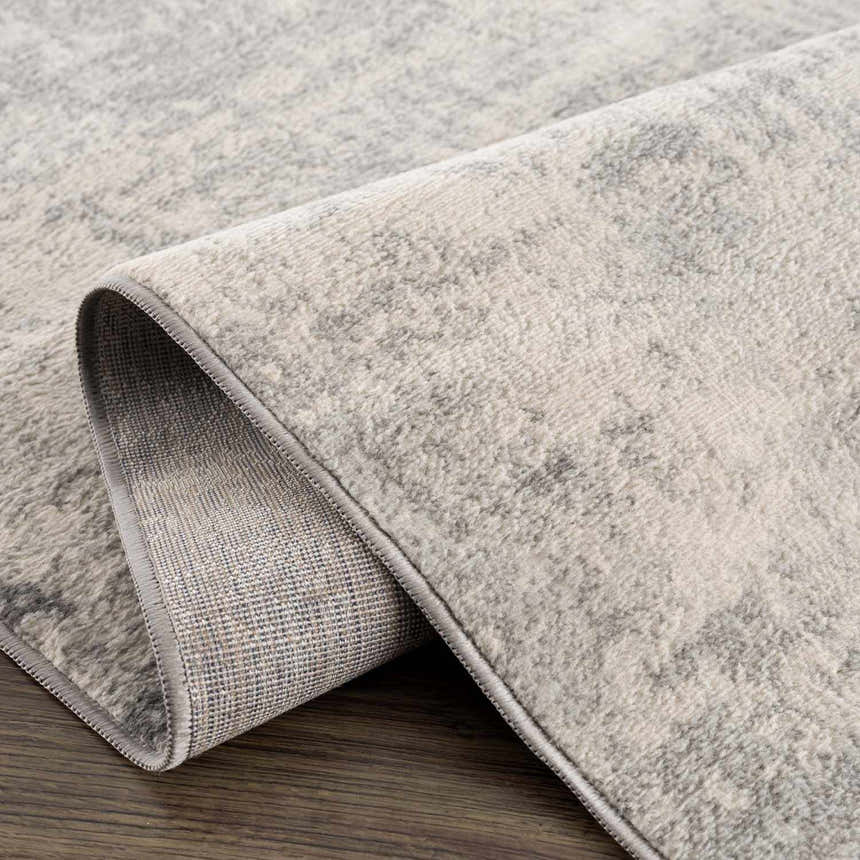 Close-up of the Kalanganan Abstract Gray Rug showing its charcoal, gray, and off-white pattern and woven texture. Fold