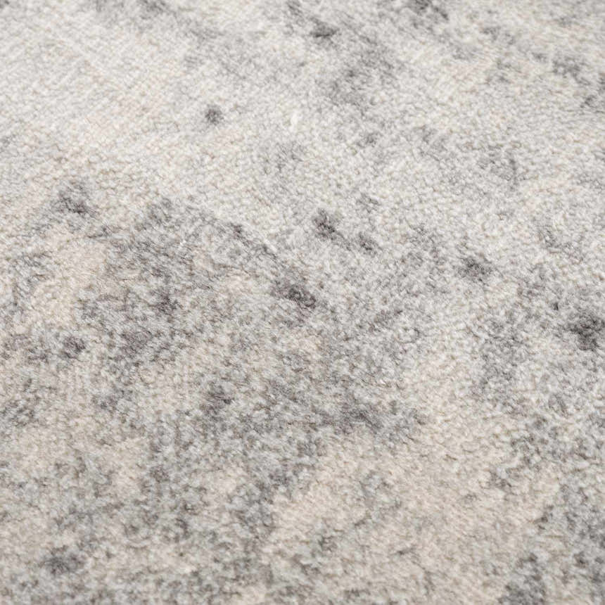 Close-up of the Kalanganan Abstract Gray Rug, showing its charcoal, gray, and off-white abstract pattern and soft, textured pile. Texture