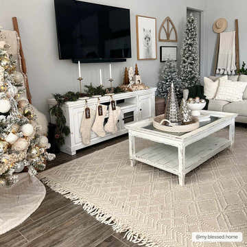 Christmas living room with Ramsbury Beige Trellis Wool Rug, white furniture, stockings, and decorated trees. Roomscene-Rectangle