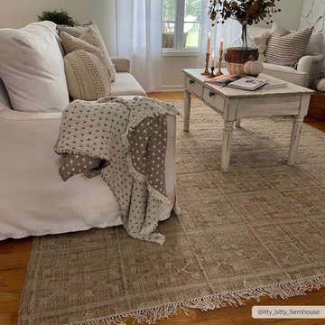 Farmhouse living room with a Rice Handcrafted Jute Carpet, white sofa, and distressed white coffee table. Roomscene-Rectangle