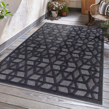 Outdoor patio scene with a black Nuri rug featuring a geometric pattern in gray and white. Roomscene-Rectangle