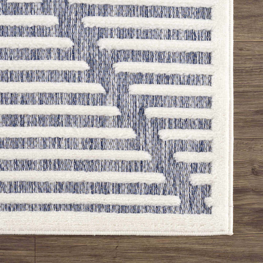 Close-up of the Anah Blue Outdoor Rug, featuring a white geometric design on a denim blue woven texture. Swatch