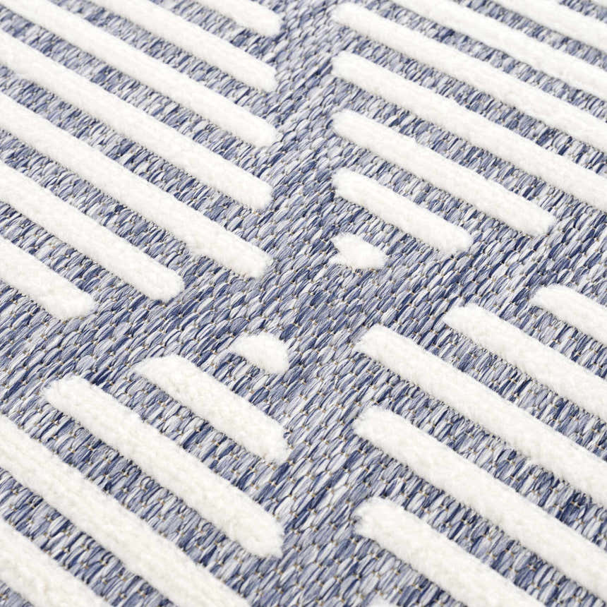Close-up of Anah Blue Outdoor Rug featuring a textured, geometric pattern in denim and off-white hues. Texture