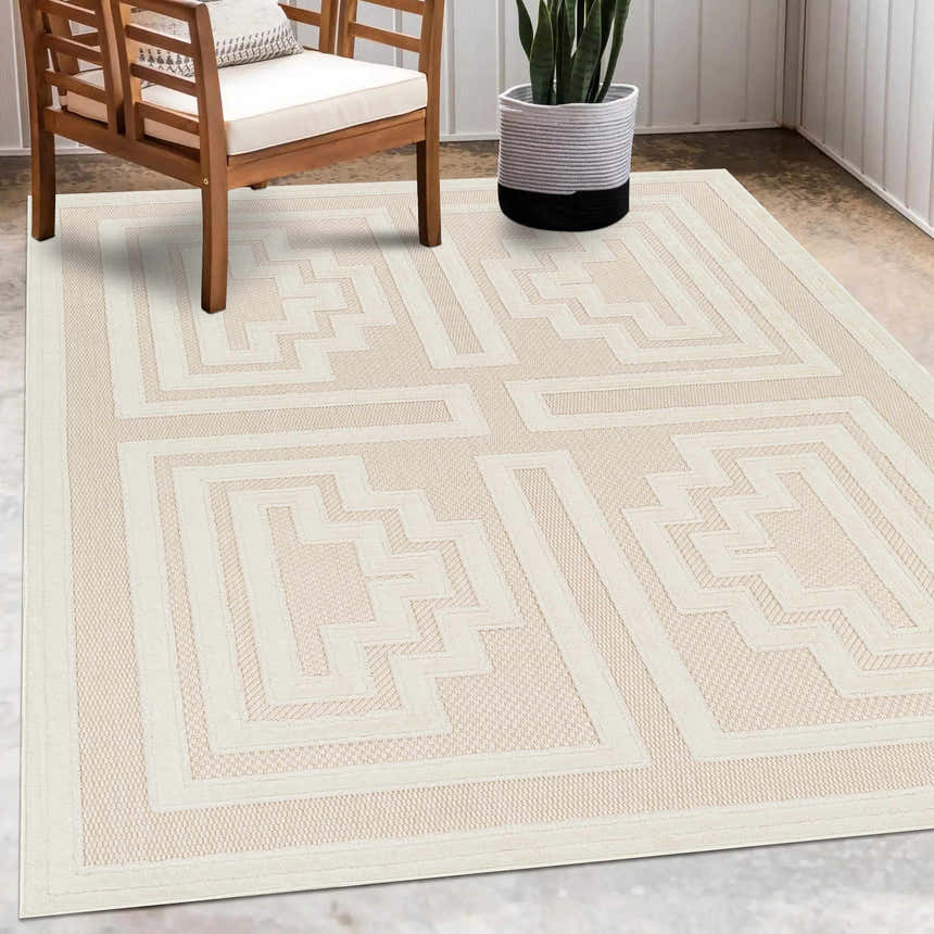 Neutral patio scene with a bone Yves Cream Outdoor Rug, wooden chair, and potted plant. Roomscene-Rectangle