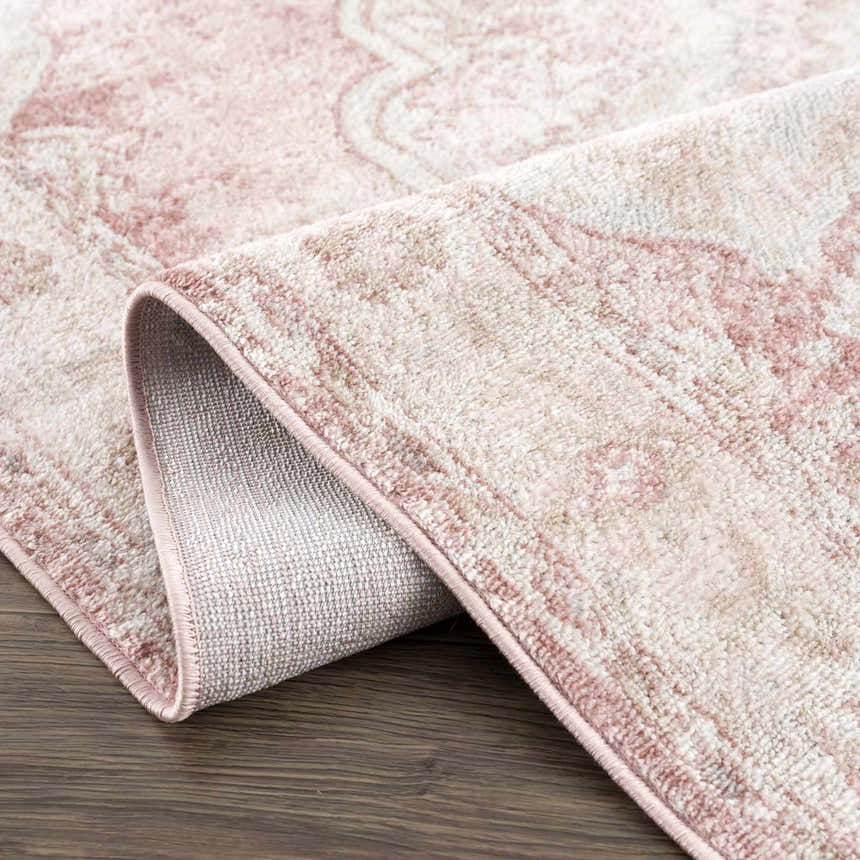 Close-up of the Kandos Blush & Light Pink Area Rug showing its traditional design, soft texture, and blush pink trim. Fold