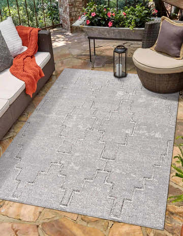 Outdoor patio scene with a bone and taupe Butch Area Rug, wicker furniture, and stone flooring. Roomscene-Rectangle