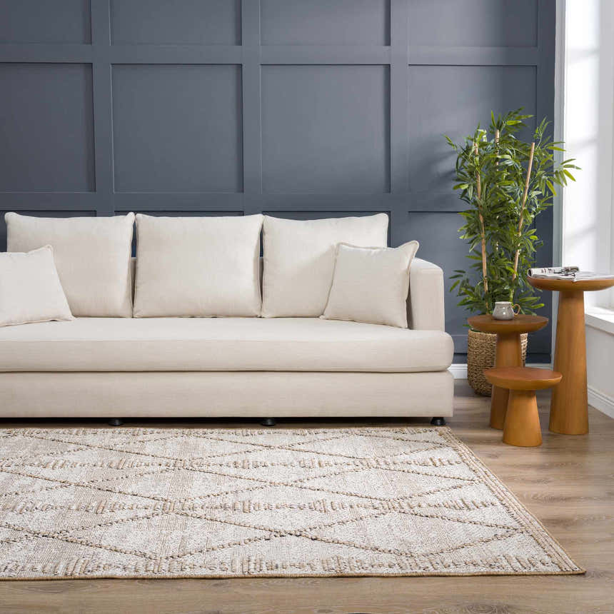 Living room scene with a Nyla Bone & Tan rug, cream sofa, wood side tables, and blue accent wall. Roomscene-Rectangle