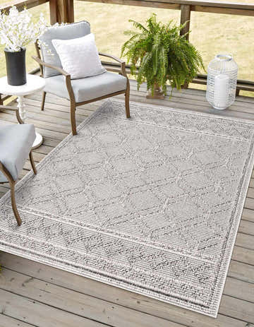 Outdoor patio scene with Diah Bone Area Rug, gray chairs, white flowers, and a fern. Roomscene-Rectangle