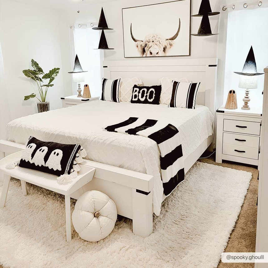 Bedroom scene with a Siari Solid Cream Plush Rug, white furniture, and black and white Halloween decor. Roomscene-Rectangle
