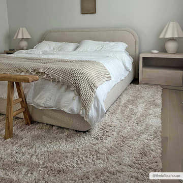 Neutral bedroom with a Siari Solid Oatmeal Shag Rug, upholstered bed, wood floors, and matching nightstands. Roomscene-Rectangle