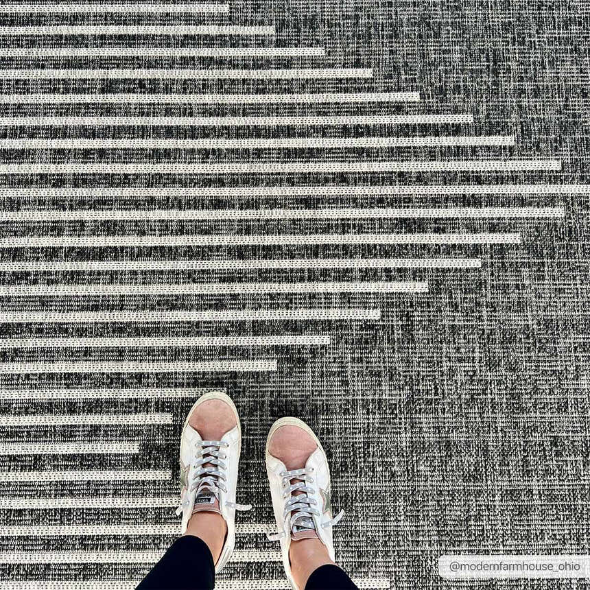 Close-up of the Stephan Area Rug featuring a black, charcoal, and cream horizontal stripe pattern. Styleshot