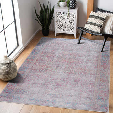 Living room scene with the Dare Distressed Washable Rug in cream, pink, and blue. Vintage rug under a black chair. Roomscene-Rectangle