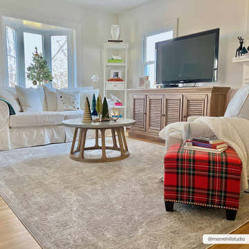 Living room scene with a beige Tahmoor Thick Luxe Area Rug, white sofa, and red plaid ottoman. Roomscene-Rectangle