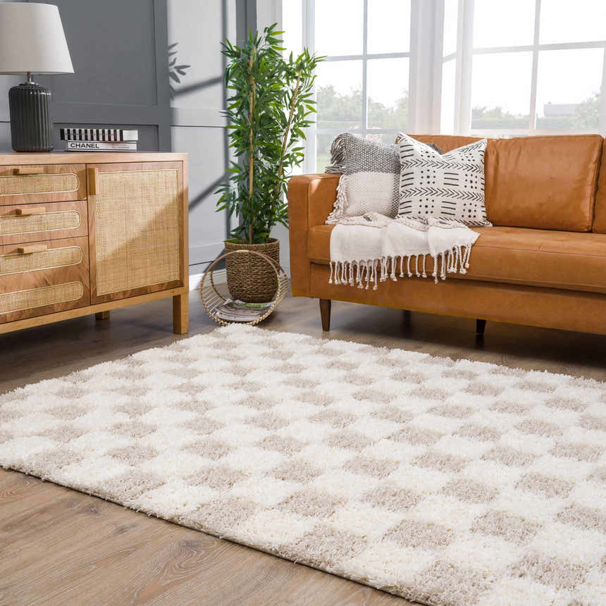 Living room with a brown leather sofa and Atira Light Brown Checkered Area Rug. Roomscene-Rectangle