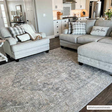 Living room scene with gray sofa and Ulubey Distressed Gray Thick Luxe Area Rug on dark wood floors. Farmhouse style. Roomscene-Rectangle