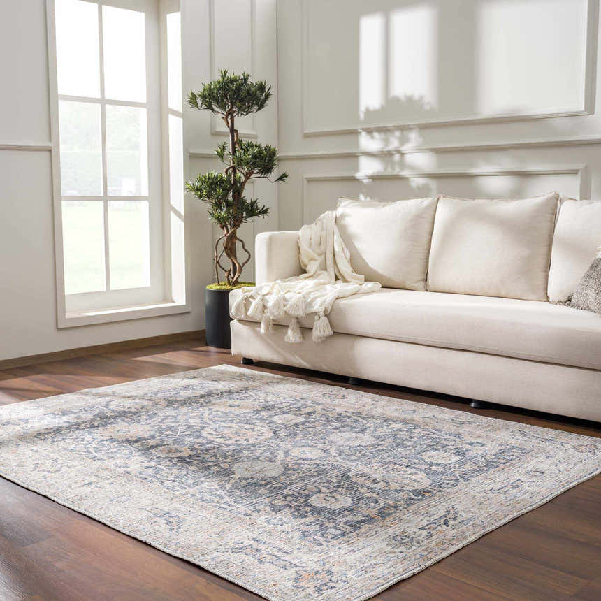 Living room scene with a silver and gray Kayin Washable Rug, cream sofa, wood floors, and natural light. Roomscene-Rectangle