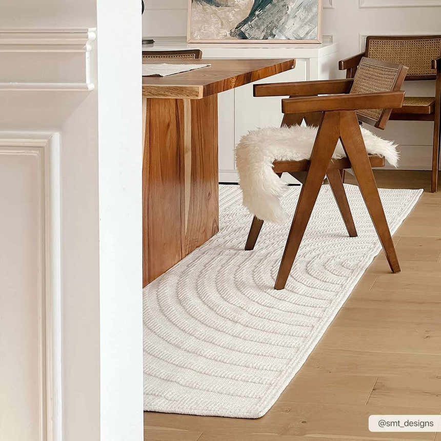 Dining room with a wood table and Deron White Washable 3D Rug in off-white with a subtle geometric pattern. Styleshot