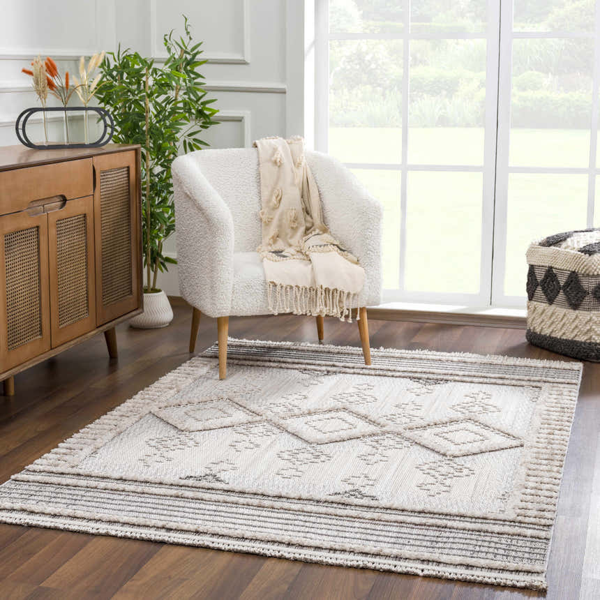 Living room scene with Amaga High-Low Rustic Rug, cream chair, wood cabinet, and neutral decor for a cozy, contemporary vibe. Roomscene-Rectangle
