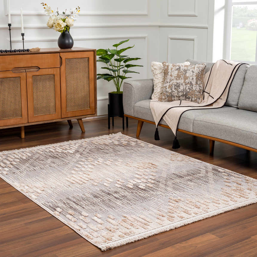 Living room scene with a Poydras High-Low Rustic Rug in charcoal, gray, and beige tones, styled with a gray sofa and wood cabinet. Roomscene-Rectangle