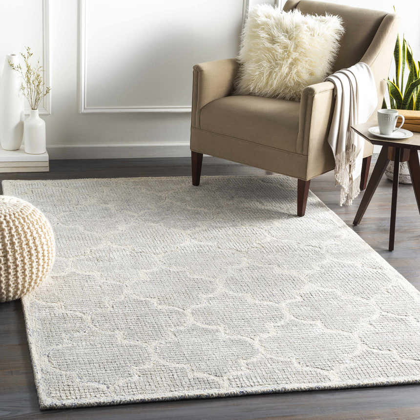 Living room scene with Abie Area Rug in blue, cream, and light slate. Neutral armchair, side table, and decor create a cozy feel. Roomscene-Rectangle