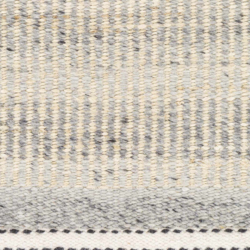 Close-up of the Abucay Jute Rug showing its hand-woven texture and pattern in charcoal, cream, light beige, and gray. Swatch