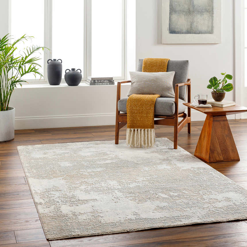 Living room scene with a gray Adwoa Boutique Rug, wood floors, chair, and side table creating a cozy, contemporary aesthetic. Roomscene-Rectangle