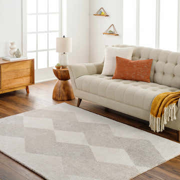 Living room scene with beige sofa and the beige geometric Alake Luxe Rug on a wood floor. Roomscene-Rectangle