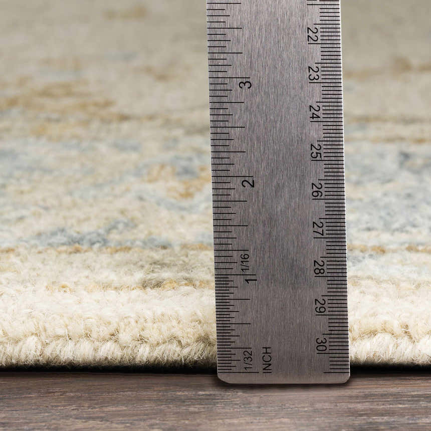 Close-up of the Albert Luxury Wool Rug pile height, showing beige, charcoal, and pale blue tones. Hand-tufted texture visible. Pile
