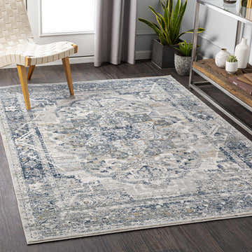 Living room scene with the Allerton Area Rug in beige, charcoal, and dark blue, styled with a modern chair and wood console table. Roomscene-Rectangle