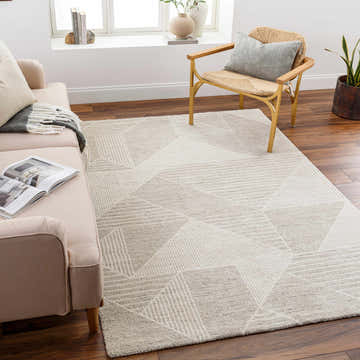 Living room scene with a cloud gray Almas Luxe rug, beige sofa, and woven chair on a dark wood floor. Roomscene-Rectangle