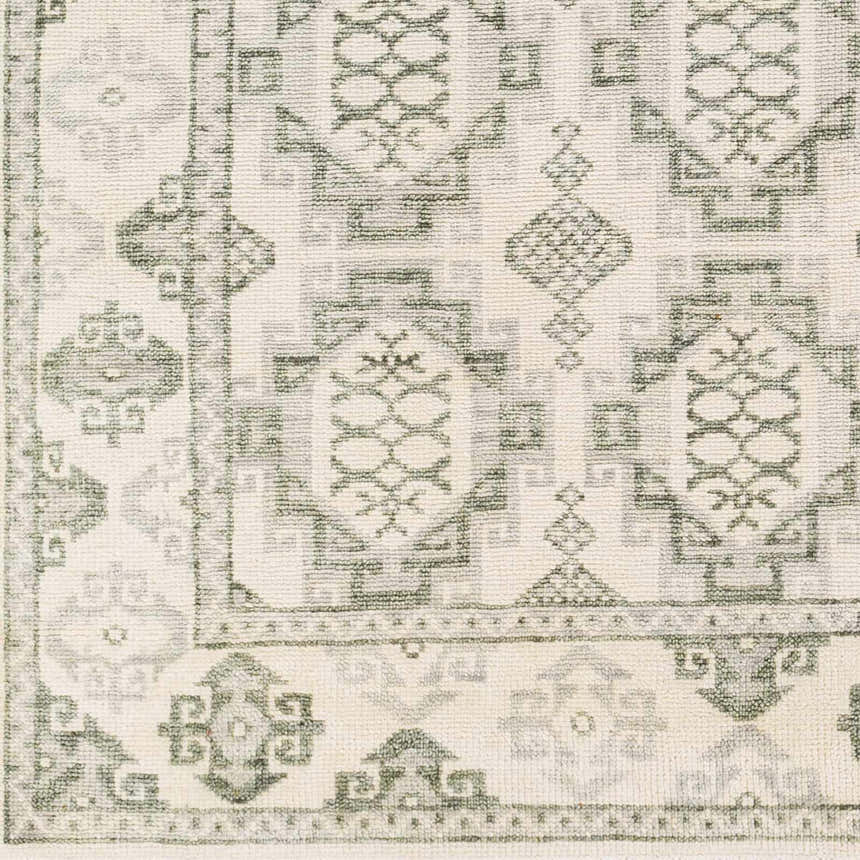 Close up of the hand-knotted Aloleng Area Rug featuring a light beige base and light sage, traditional patterns. Swatch