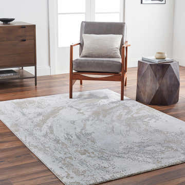 Living room scene with a gray Ambra Thick Luxe Boutique Rug, gray chair, wood accents, and light walls. Roomscene-Rectangle