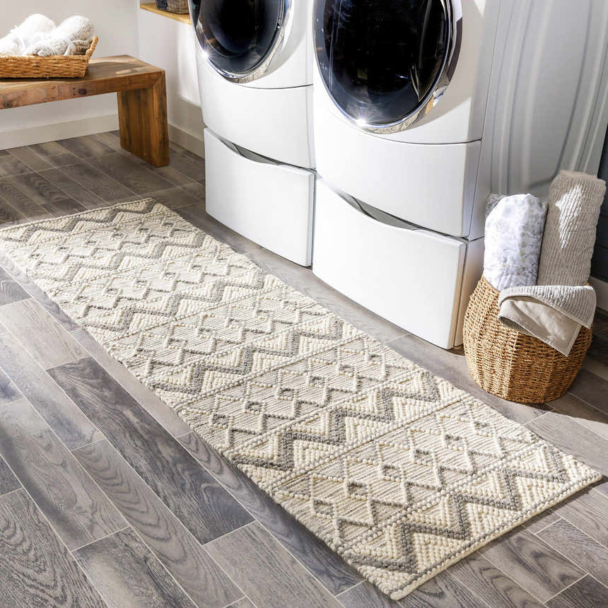 Laundry room scene with a gray wood floor and the Whittington Gray&Cream Wool Rug runner in front of a white washer and dryer. Roomscene-Runner