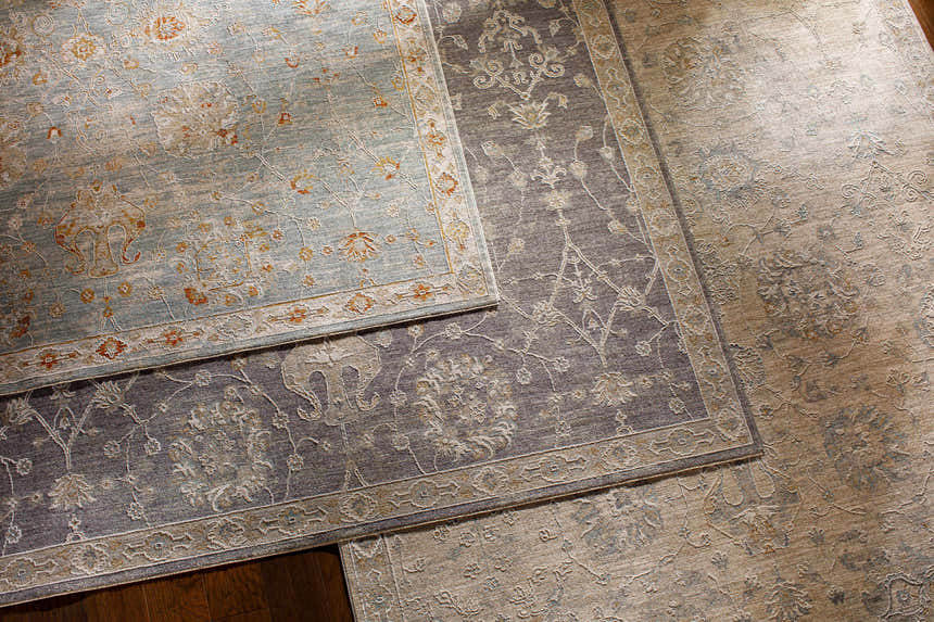 Close-up of Mangham Thick Luxe Area Rugs in blue, brick red, and light beige with traditional floral patterns and machine woven texture. Styleshot